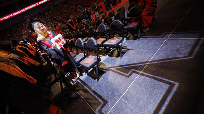 Lauren Williams, in graduation attire, is highlighted by an N spotlight.