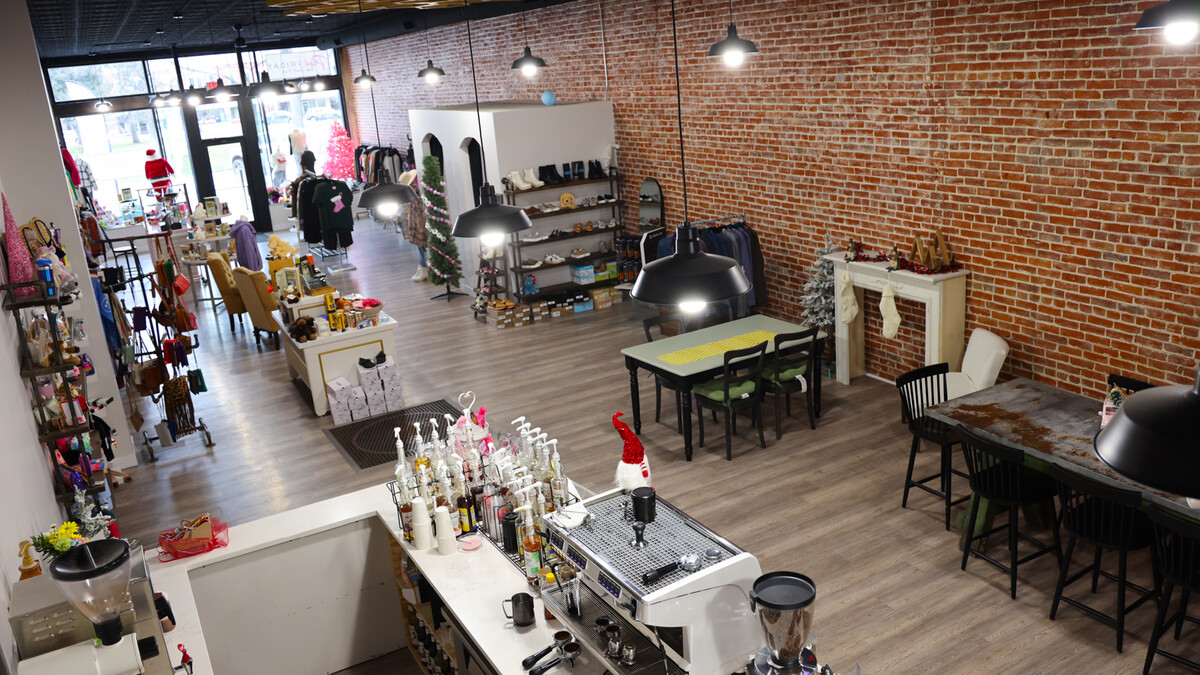A boutique and coffee shop with tables for customers.