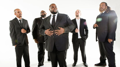 Five men — members of Big Wade and Black Swan Theory — stand in black suits against a white background.