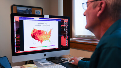 Bill Sorenson, senior applications/systems programmer for the High Plains Regional Climate Center, reviews an Applied Climate Information System map showing precipitation levels throughout the country during the last four months.