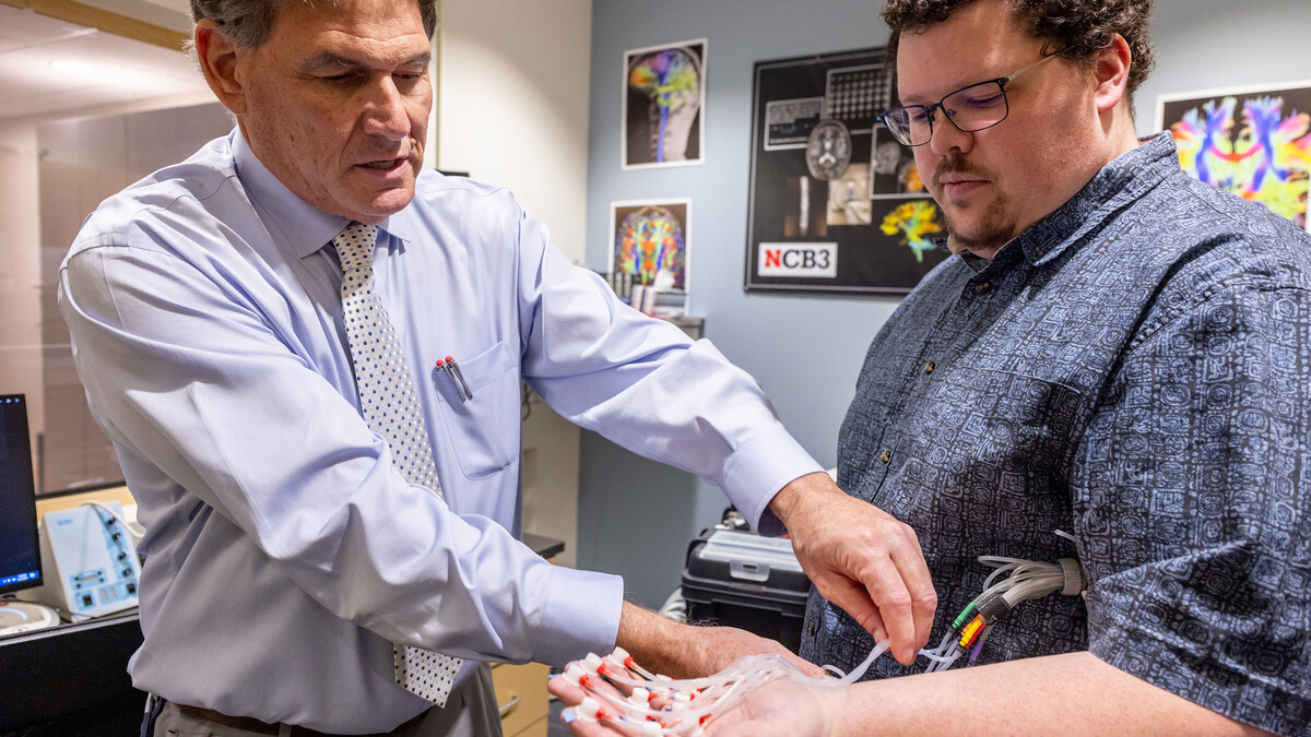 Steven Barlow (left) attaches the pTACS' thermoplastic tactile ‘touch’ capsules to the hand of Jacob Greenwood.