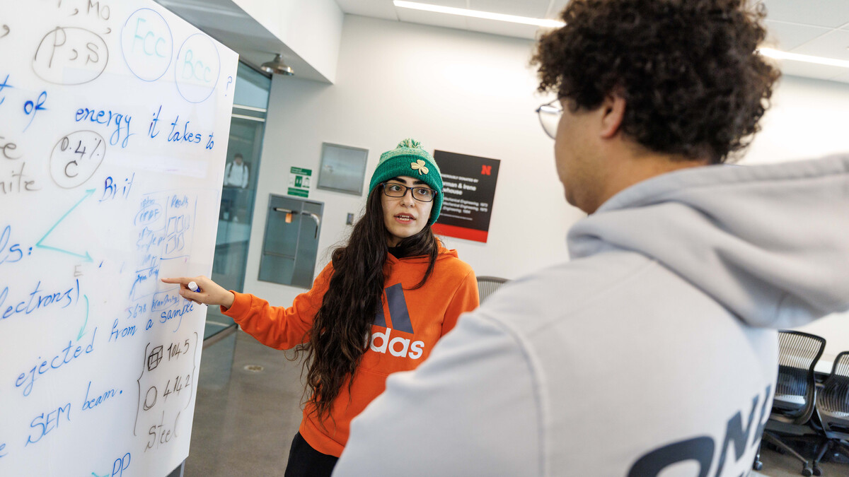 Graduate student Sahar Beigzadeh (left) shows freshman Ahmed Salem how to record findings from microhardness testing inside Kiewit Hall in December 2024.