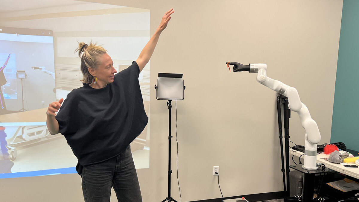 Ash Eliza Smith guides a robotic arm in the Speculative Robotics Lab. 