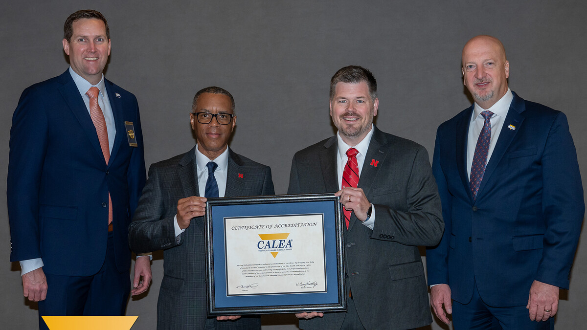 University of Nebraska–Lincoln Police Department Chief Hassan Ramzah (second from left) and accreditation and compliance manager Jon-Michael McDaniel (third from left) stand with others onstage at a conference in Tucson, Arizona, as they receive the department’s fourth accreditation.