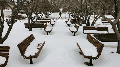 A student walks by the snow-covered benches in the plaza north of the Lied Center for Performing Arts. After a record-setting snowfall delayed the start of the "spring" semester, the second week of February featured temperatures that have struggled to reach double digits.