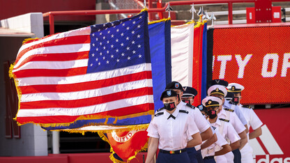 UNL's ROTC combined color guard stands at attention with flags in hand during commencement exercises in Memorial Stadium on May 8.