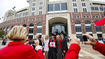 A family shoots a post-commencement photo of a new Husker graduate outside of Memorial Stadium on May 8.