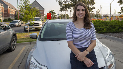 Nebraska's Bonnie Martin rests on her car after a quick commute on July 21. Martin  — who won free reserved parking for a year —was the first university employee to earn a prize through the voluntary vaccine registry giveaway.