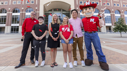 Voluntary COVID-19 Vaccine Registry grand prize winners stand with Chancellor Ronnie Green and Herbie Husker on the east side of Memorial Stadium.
