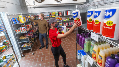 Morgan Berg (right), a senior in psychology from West Fargo, North Dakota, and Tim Anderson, a third-year law student from Huntington Beach, California, stock the shelves in the new East Campus Food Pantry. The pantry is in Filley Hall in the old Dairy Store walk-in freezer