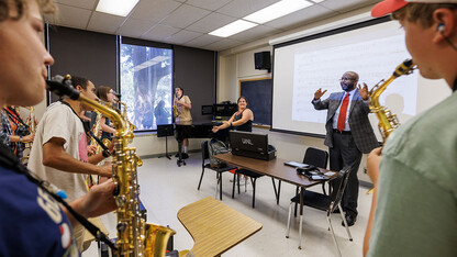 Chancellor Rodney Bennett follows the direction of Drum Major Steffani Nolda, center, and saxophone section leader Cyphers Stewart as Bennett helps lead the saxophone section in the fight song.