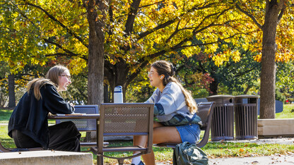 Josie Bartels, a junior from Lincoln, left, and Audrey Ellis, a sophomore from Fort Worth, Texas, laugh over the various methods of murder Bartels’ criminal justice book describes as they study outside of the Adele Coryell Hall Learning Commons.