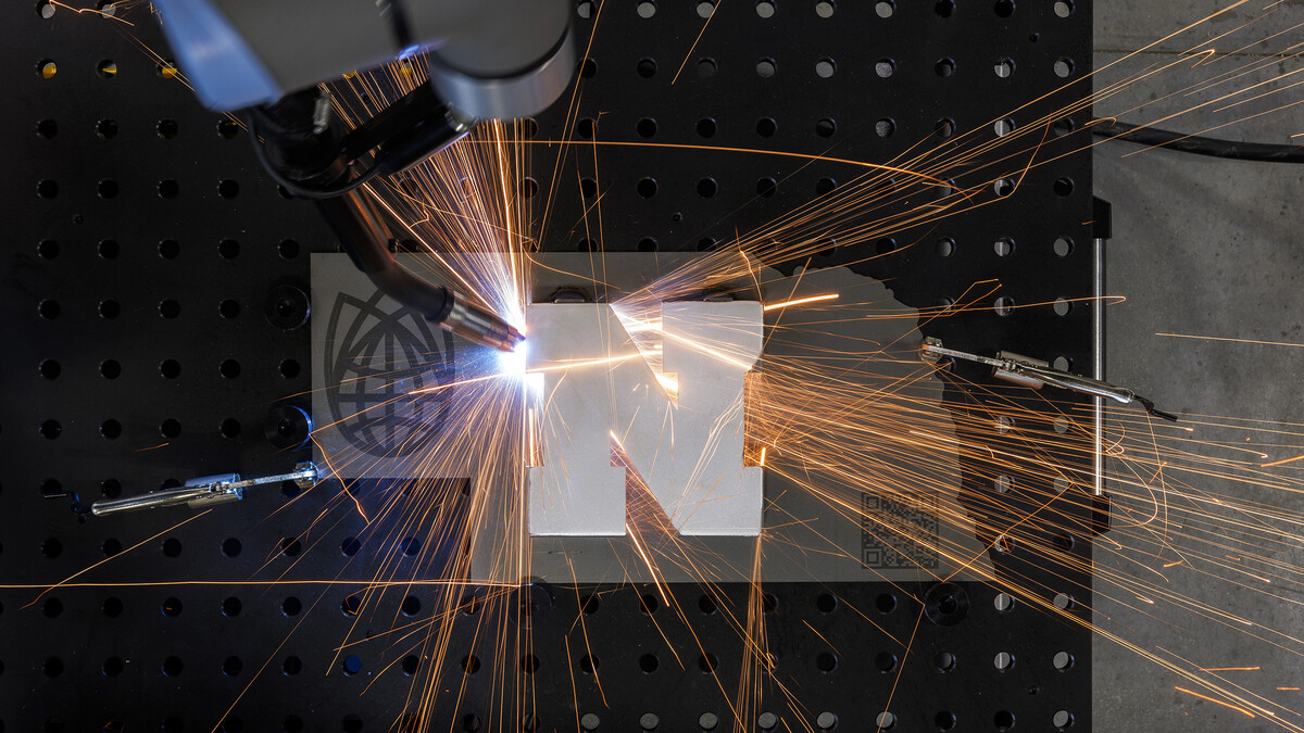 A robotic welder works around a Nebraska "N" at Nebraska Innovation Studio