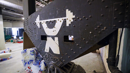 Stenciled to a girder was a stylized Nebraska weightlifter from when the area was a weight room. Construction continues to renovate the locker rooms and a new weight training and conditioning area.