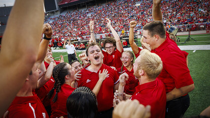 A group of Cornhusker Marching Band members celebrate following a competition during the annual exhibition in Memorial Stadium.