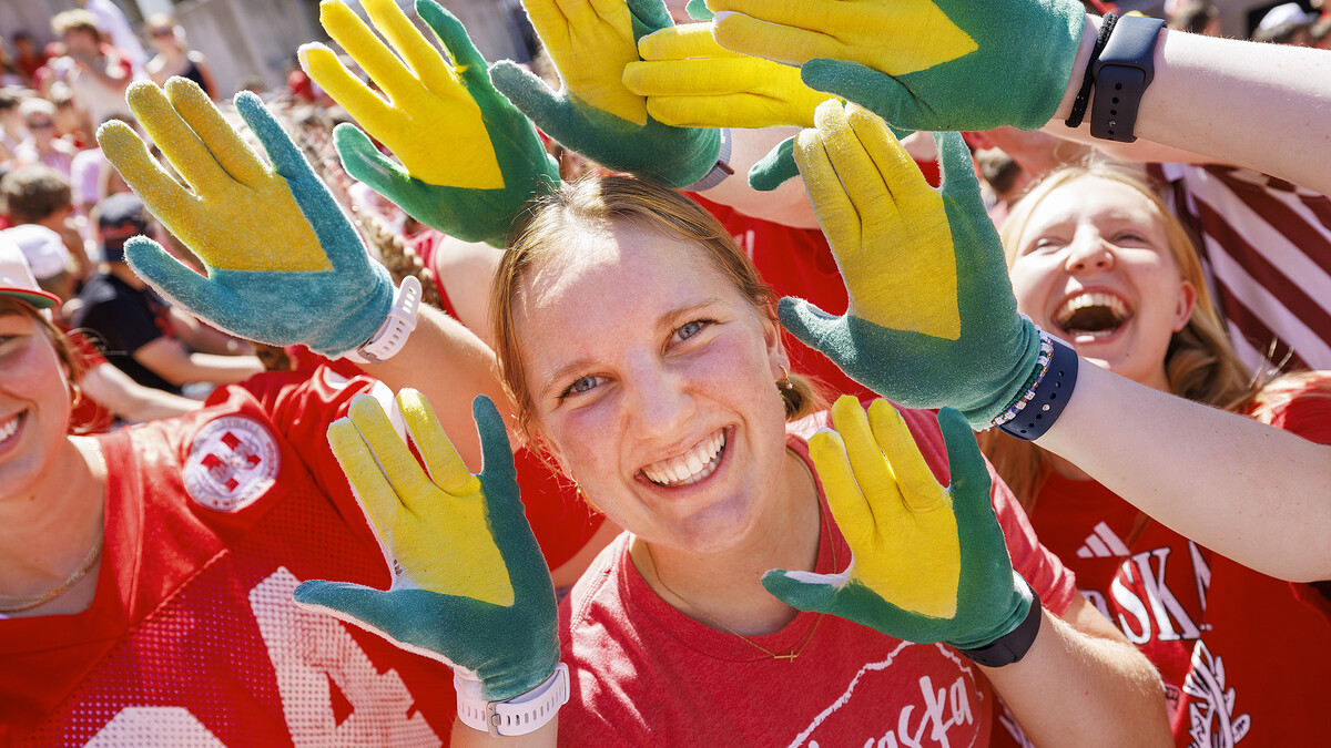 Carrie Wehrman is surrounded by yellow and green corn gloves