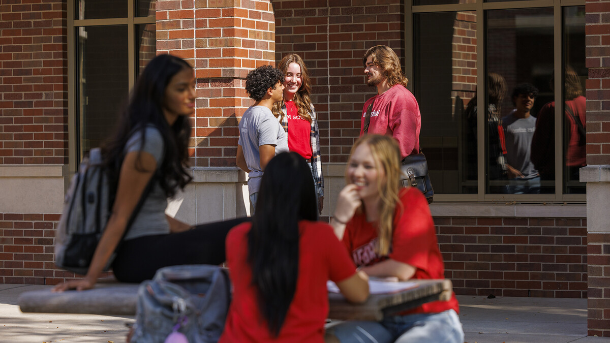 Viraj Karthik, Nick Coldiron, and Kate McKinzie talk outside the Raikes school as they enjoy the fall sunshine. 