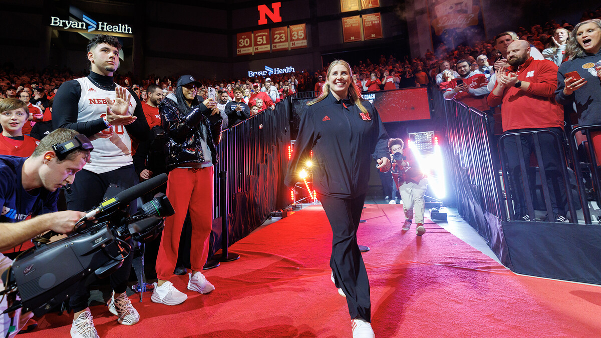 Alumna Dani Busboom Kelly, Nebraska volleyball’s new head coach, walks on a red carpet and toward the court at Pinnacle Bank Arena while being introduced during a break in the men’s Jan. 30 basketball win over No. 23 Illinois. Busboom Kelly, a libero on Nebraska volleyball’s 2006 national championship team, succeeds her former coach and mentor, John Cook, who announced his retirement after 25 seasons leading the team.