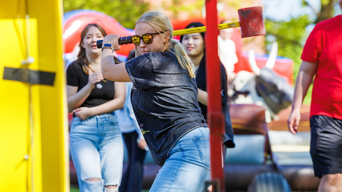 Claire Gangwish, prepares to hit the Highstriker’s bell will a hammer during the End of Year Bash on East Campus.