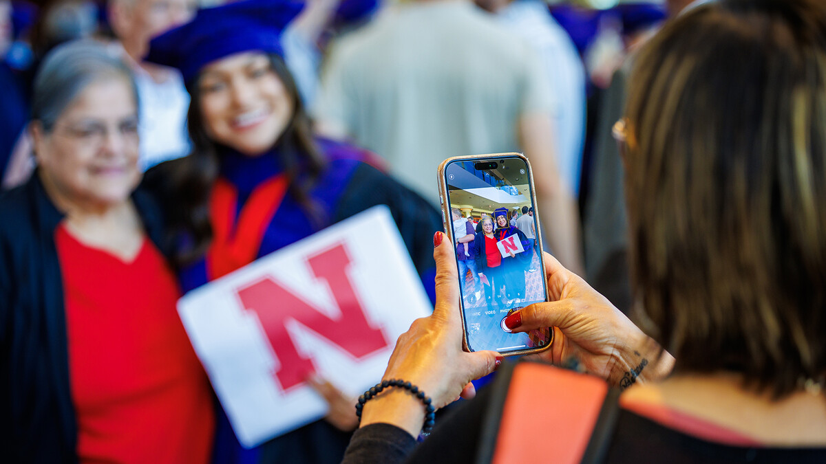 Jori Peters smiles as her photo is taken with a family member after the Nebraska Law graduation ceremony on May 3.