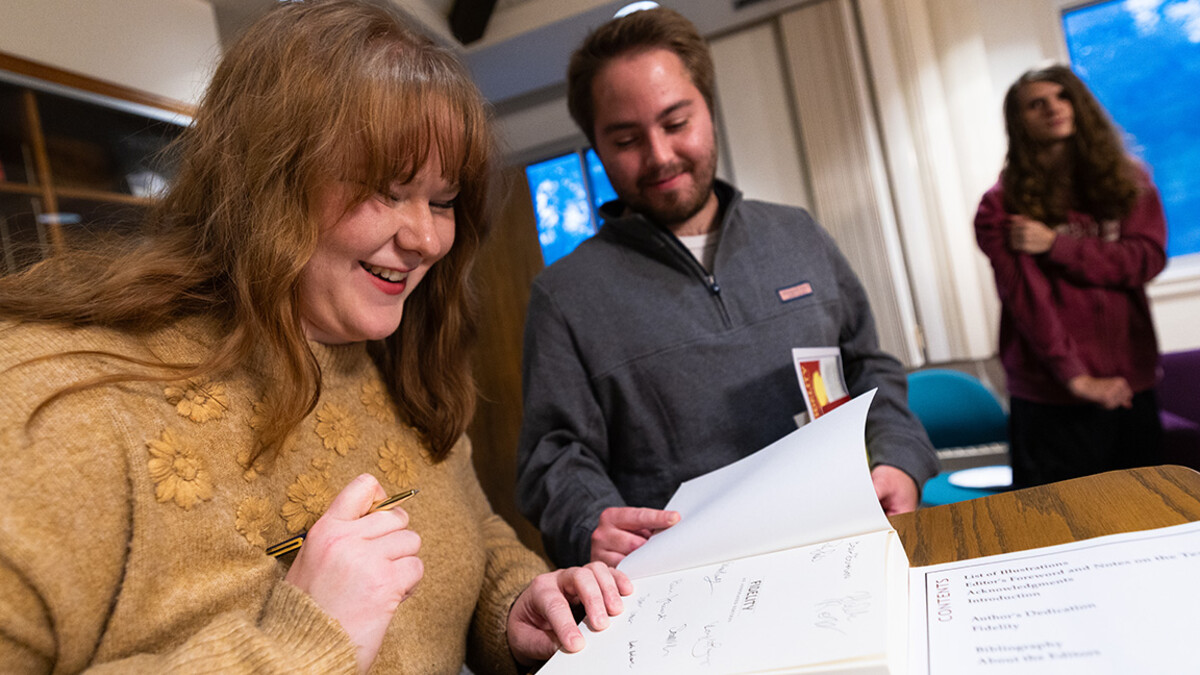 Sophie Anderson, a 2025 graduate, signs a copy of "Fidelity," by Susan Glaspell. Anderson was one of the 27 students in Kevin McMullen's spring 2024 ENG 355 course who edited and annotated the book, which was reprinted by Saluki Publishing and officially released on October 24, 2025.