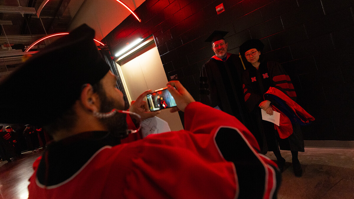 Gautham Takoo, a research technologist in the Department of Agronomy and Horticulture, snaps a photo of Sunhyoung Lee and her adviser, James Boviard, professor of educational psychology. Lee graduated with her doctorate in educational psychology.