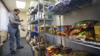 Cody McCain, a sophomore accounting and agribusiness major from Aurora, places donations on shelves in the university's current food pantry. McCain is the coordinator for the food pantry, which is located in the Lutheran Center. The university is opening an expanded food pantry in the Nebraska Union in January.