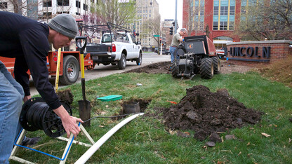 UNL landscape services employees Michael Tomjack (left) and Fred Thorne use a vibrating plow to install new irrigation pipe by the Van Brunt Visitors Center. UNL has started a campuswide upgrade of its irrigation system. When complete, it is projected to decrease campus water usage by at least 20 percent annually.