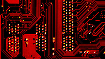 Photo of a circuit board reflected with red light.