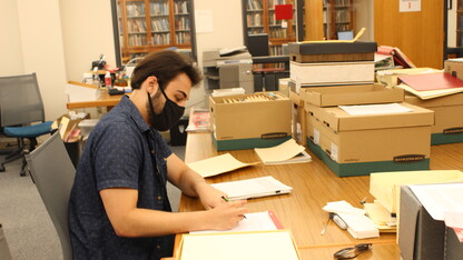 Jake Borgmann, senior, works in the Archives & Special Collections processing the Mark Awakuni-Swetland Papers.