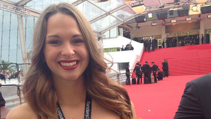 Aliza Brugger stands on the red carpet at the 2014 Cannes Film Festival. She is the first UNL student to have a film screened at the international festival.