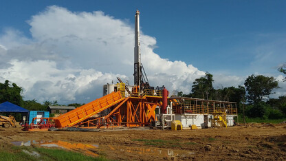 A drill rig stands in the Amazon rainforest.