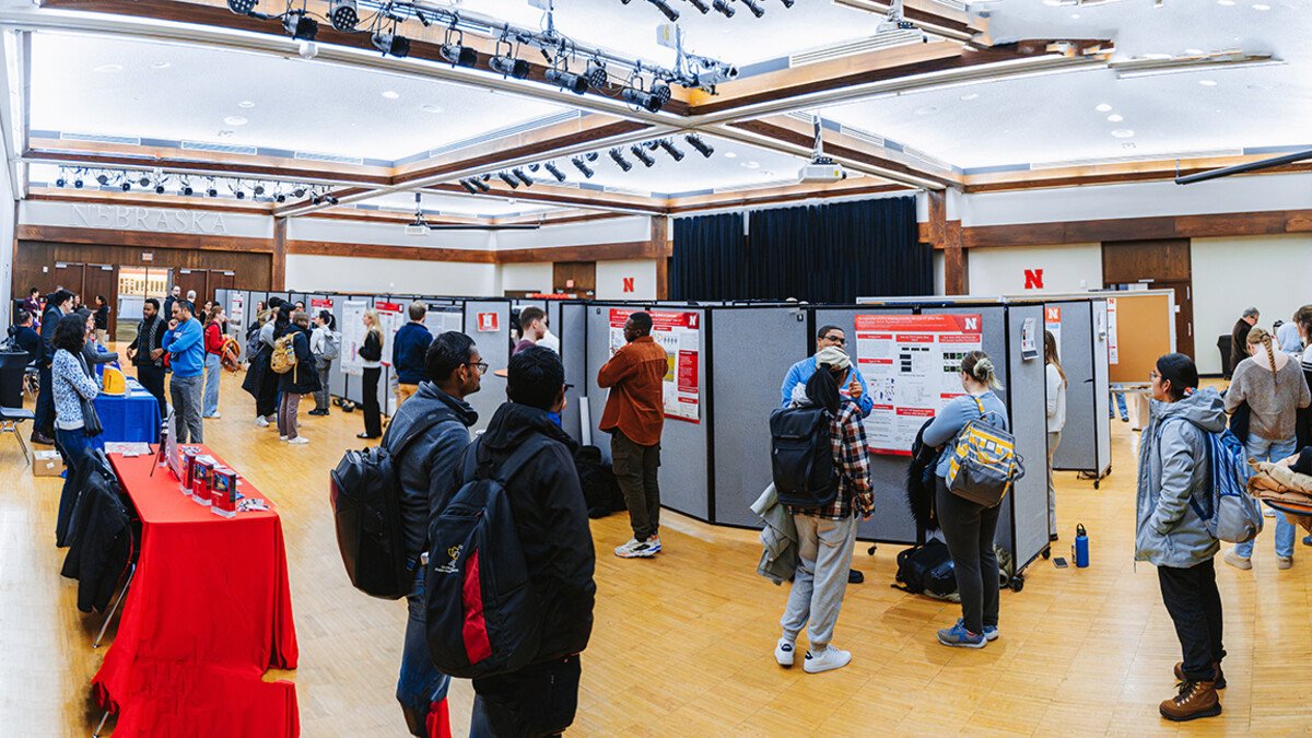 Fall 2025 UNL Microbiology Research Symposium Poster Presenters along sponsorship tables.