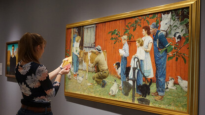 A Nebraska student uses paint swatches to match colors to Norman Rockwell's "The County Agricultural Agent" painting in the Sheldon. The project was part of a Textiles, Merchandising and Fashion Design class project to create a color palette based on a Sheldon artwork.