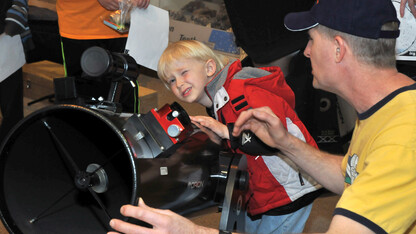 Dan Kincheloe, a member of the Prairie Astronomy Club, helps Benjamin Mount with a telescope during Astronomy Day at Morrill Hall. The museum's Sunday with a Scientist program will feature telescopes and the night sky on Sept. 22.