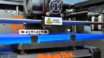 Print Services’ MakerBot Replicator 2 printer creates a five-link chain by building up paper-thin layers of a melted, corn based plastic.