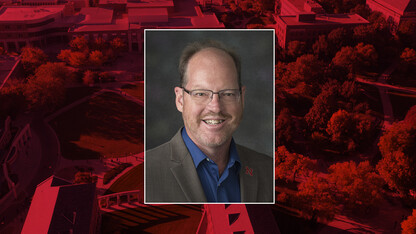 Patrick Dussault in portrait on red background.