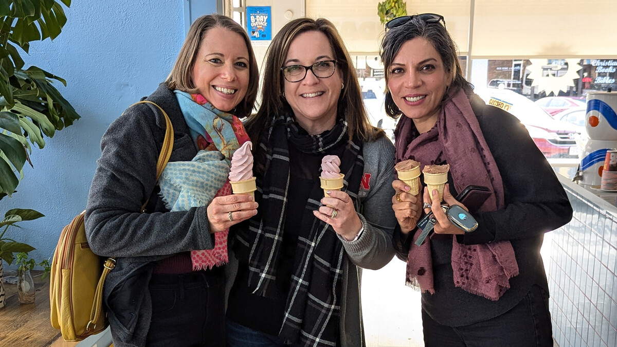 Nebraska's Sabrina Ehmke Sergeant (left) stands with two friends, each enjoying an ice cream cone in an ice cream store.