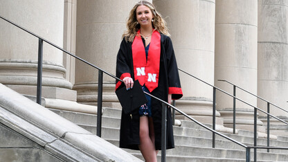 Emily Stratmoen in graduation gown on university steps