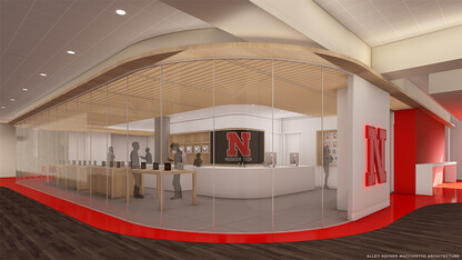 Rendering that shows the redesigned HuskerTech space on the first floor of the Nebraska Union. Image shows a glass-enclosed store with a white counter inside and a back wall with an iconic Nebraska "N" on the wall.