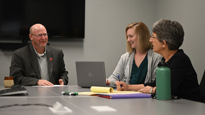 Center on Children, Families and the Law members (from left) Jeff Chambers, Brittany Brakenhoff and Michelle Graef talk about a project around a table.