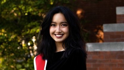 Dilziba Kizghin smiles for a photo outside Architecture Hall in her Innocents Society sash.