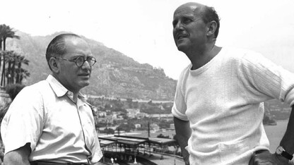 Black and white image of two men standing on a movie set.