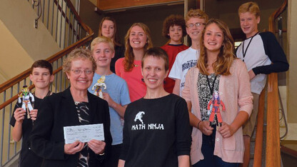 Jocelyn Bosley (front row, second from left) presents a Math Hero award check to members of Irving Middle School. Bosley's 2015 Math Hero award included funds for the institution she worked with on her mentoring project.