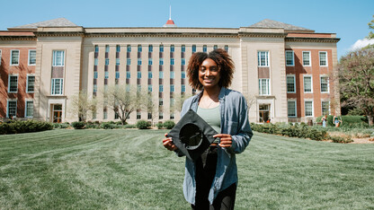 Standing in front of Love Library, Wright shows off a Grad Cap Remix insert.  