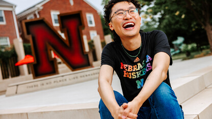 Nathan laughs for a photo on the stairs of the Wick Alumni Center