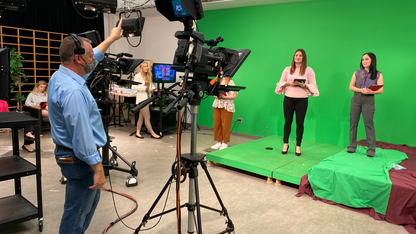 Anchors Kloee Sander, left, and Hallie Gutzwiller prepare for the Nebraska Nightly show open. Faculty liaison Brian Petrotta provides a countdown.