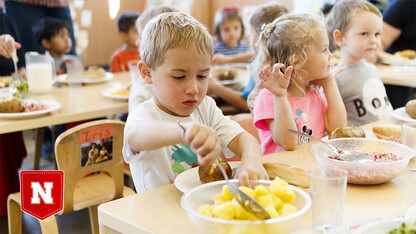 A child takes a helping of pineapple in a child care setting
