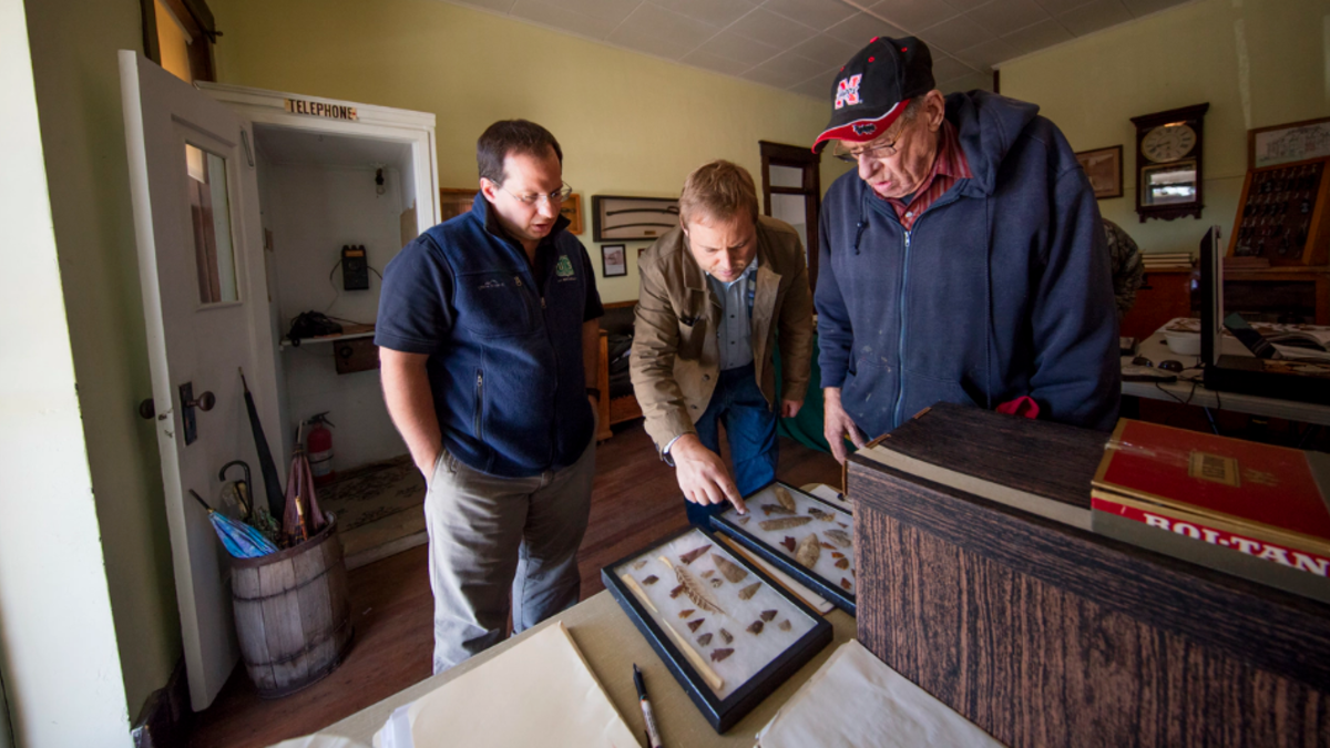 Dennis Kuhnel (from left) and Matt Douglass examine a collection brought in by John Furrow during an Oct. 7, 2016 Artifacts Roadshow in Mullen, Neb.