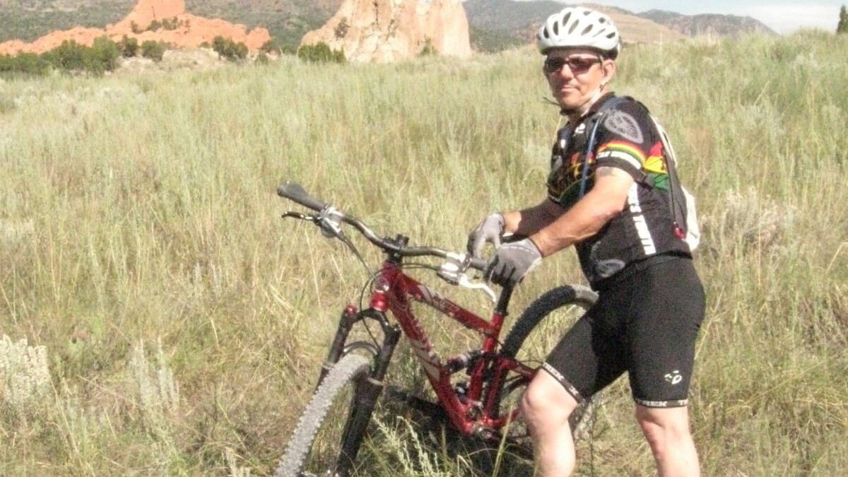 David Torquati standing with his bike along a rural Nebraska trail.